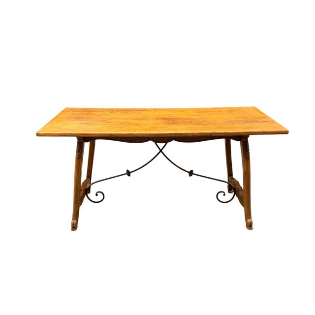 French Provençal table, circa 1920, in the Arts & Crafts style, made of oak, with decorative wrought iron reinforcements...
