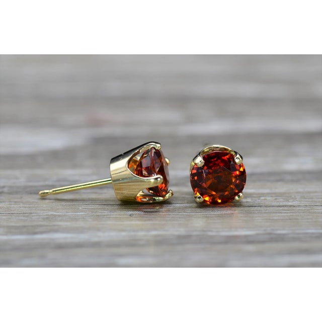 Ladies 14K Spessartite Garnet Stud Earrings. Crafted in 14 karat yellow gold are four prong set 6.5mm spessartite garnets....