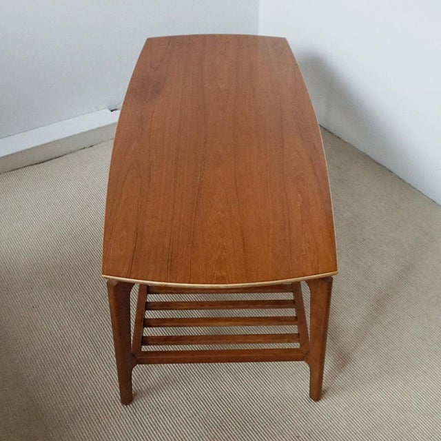 A mid-century coffee table. Two tiered with lower magazine rack. Solid teak. Dimensions: h 44.5cm w 130cm d 57.5cm origin:...