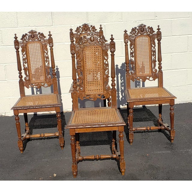 A very decorative, intricately carved antique Jacobean chairs in oak and cane. A set of 4. They have elaborately carved...