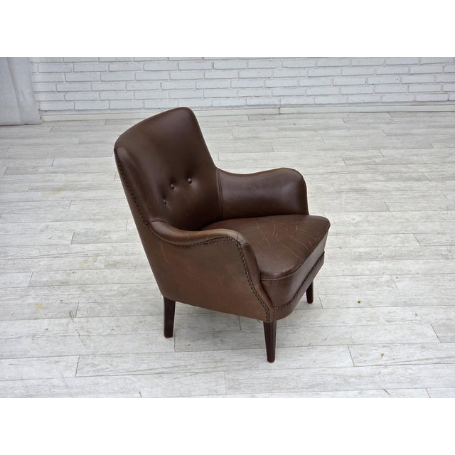 1960s, Danish armchair. Brown furniture leather, ash wood legs, springs in the seat. Original good condition no smells, no...