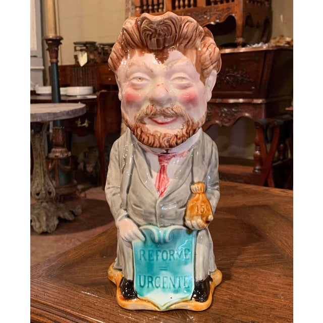 This large Majolica water pitcher with back handle was crafted by Onnaing in Northern France, circa 1910. The colorful...