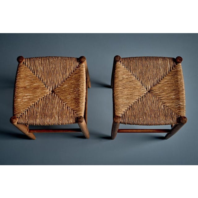 Pair of French stools from the 1950s, featuring solid beechwood frames and rush wicker seats. The square seats have a...