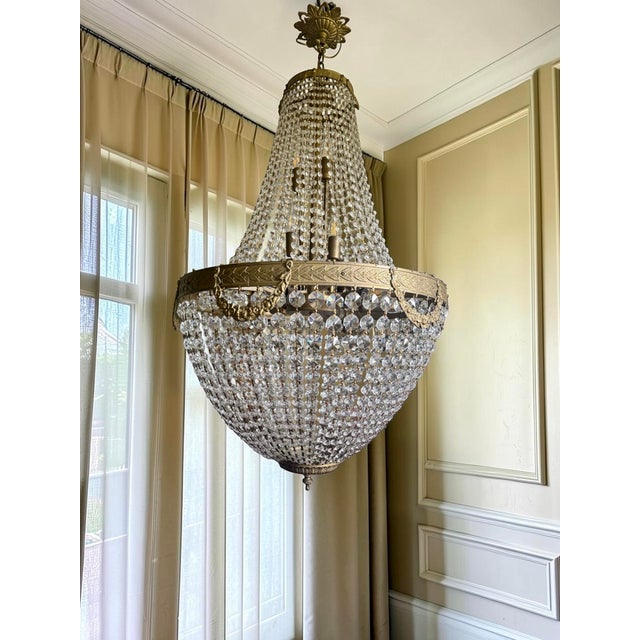An absolute eye-catcher! This imposing Empire-style chandelier is richly finished with a beautifully engraved brass frame,...