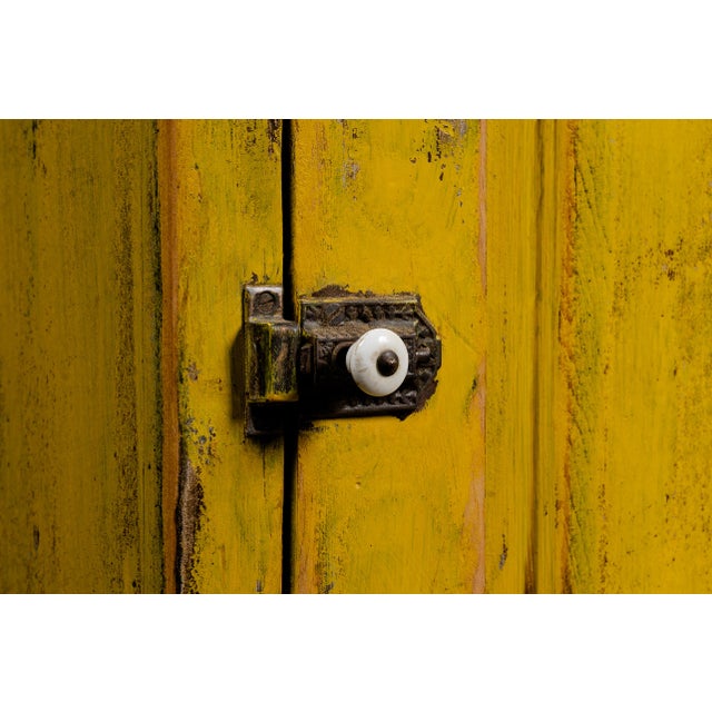 Handpicked by IndustrialArtifact Vintage from the 1950s About this item This antique cabinet features a worn yellow paint...