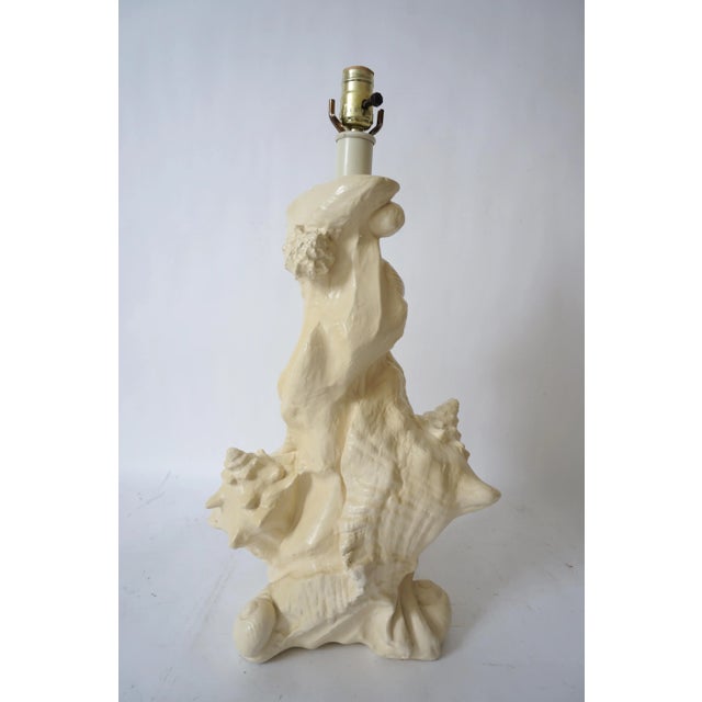 This stylish and chic Sirmos seashell encrusted motif table lamp dates to the 1970s-1980s and is a molded plaster...