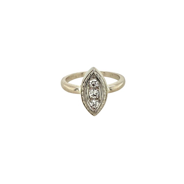 A fine vintage 14K white gold and diamond navette ring. The ring is set with three .8 ct diamonds with an engraved bezel...