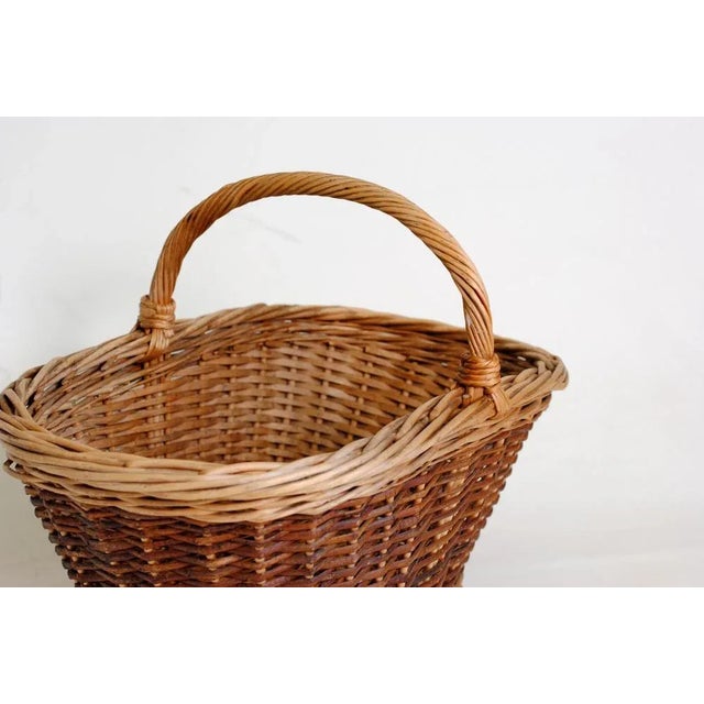 This vintage woven basket features a natural design with a braided handle. The warm, earthy tones add rustic charm to your...