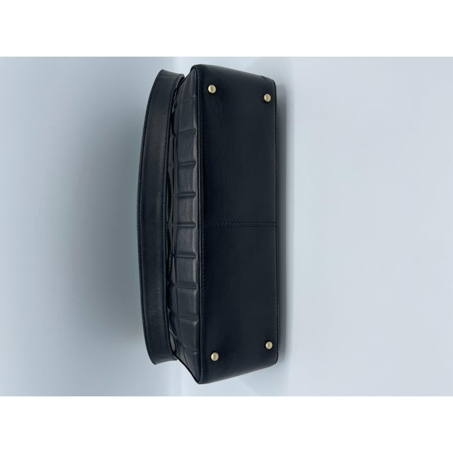 This chocolate bar bag is crafted from black leather with Chanel's signature square stitching and has an adjustable...