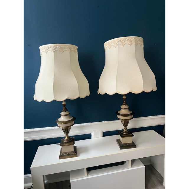 A sophisticated pair of vintage Stiffel table lamps, crafted in enameled brass with a timeless neoclassical silhouette....