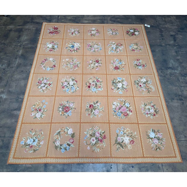 This mid-century French Aubusson rug, dating to the 1950s, features a beautifully structured panel design composed of...