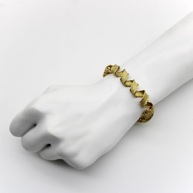 This 18k gold bracelet made by Tiffany & Co. in Paris, France exhibits exquisite craftsmanship. The design has an...