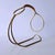 Brass wine rack in the Mid-Century Modern style with a woven raffia handle. This bottle rack is made of brass and features...