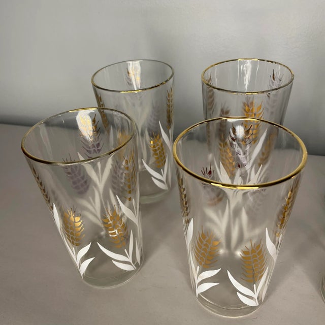 Set of eight highboys / tall tumblers with white and gold wheat designs. The glasses are free from chips or cracks. Some...
