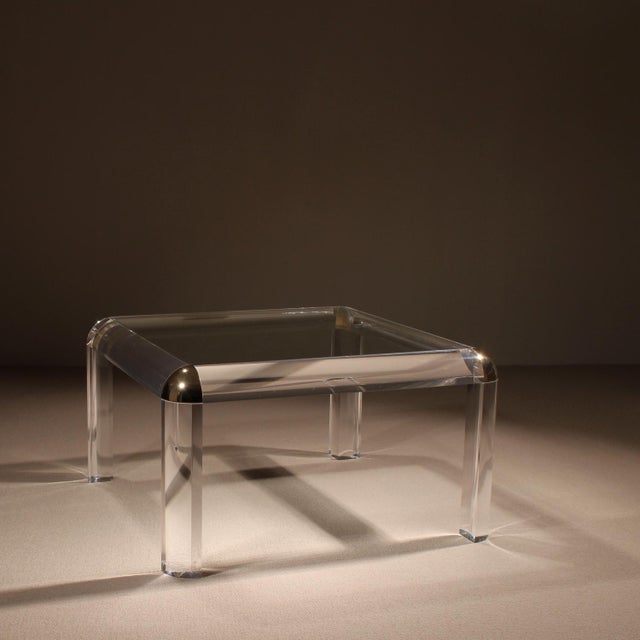 ​This striking square coffee table is an exceptional statement piece of 1970s Hollywood Regency design. It impresses with...