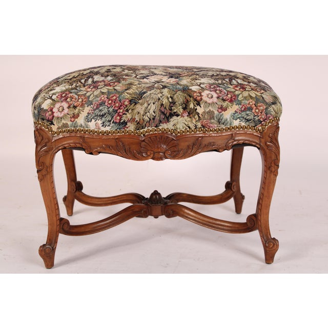 Antique Louis XV provincial style bench, circa 1920's. With a tapestry style seat with brass nail head trim, acanthus and...