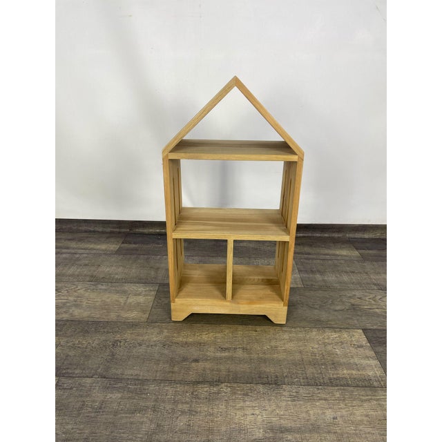 Indian Rosewood Bookcase A wooden shelf in the shape of a house with three levels and two compartments on the lower shelf....
