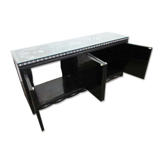 Black painted sideboard cabinet with mother of pearl inlays and glass top. The inlays, on both sides, the front, and the...