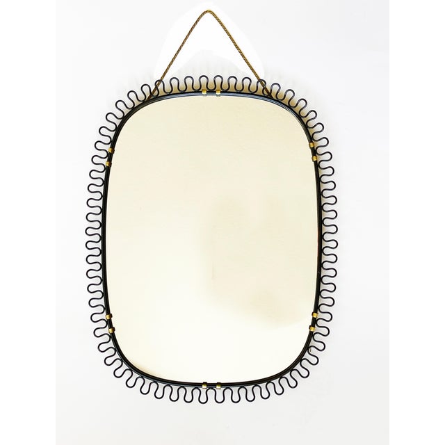 This mid-century modern oval-shaped wall mirror is both sculptural and elegant, designed by Josef Frank. , Austria/Sweden,...