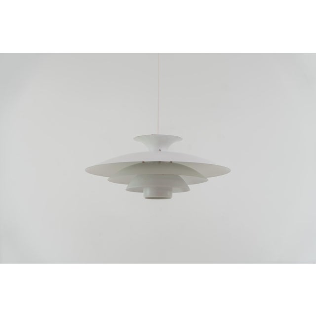 Pendant light by Form Light (Denmark, 1970s). The lamp is crafted out of five metal shades and gives a stunning light...