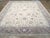 A wool pile of symmetric knots on a wool foundation. The warm cream straw field shows a barbed primary arabesque vin...