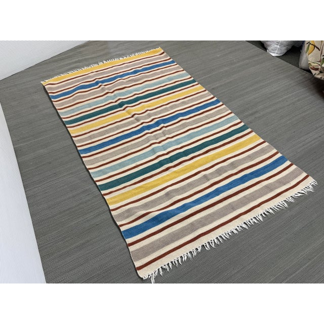 Design Plus Gallery presents a 3ft 9in × 6ft 5in Striped Area Rug that is Flat Woven. The rug has a charming sense of...