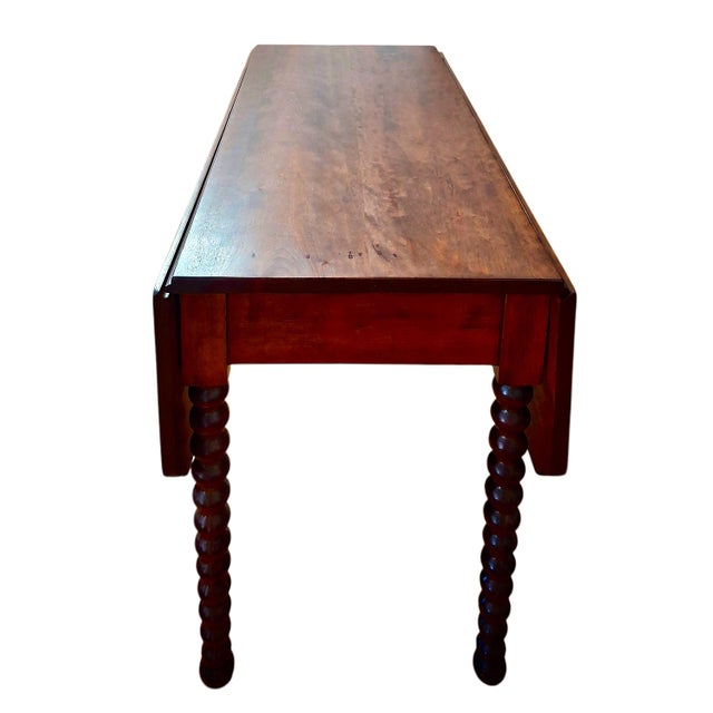 On offer is a handsome solid mahogany drop-leaf table with center cut shaped corners and bobbin-turned legs. It is a...