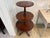 Elegant three-tier mahogany dumbwaiter table with graduated round shelves and a turned central column. The rich, warm...