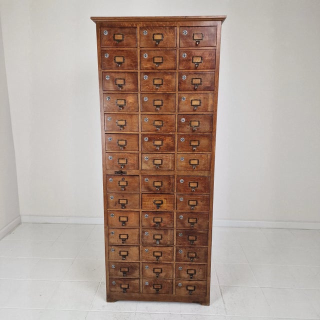 A striking early 20th-century Dutch industrial cabinet with 42 drawers, crafted from solid oak and exuding timeless...