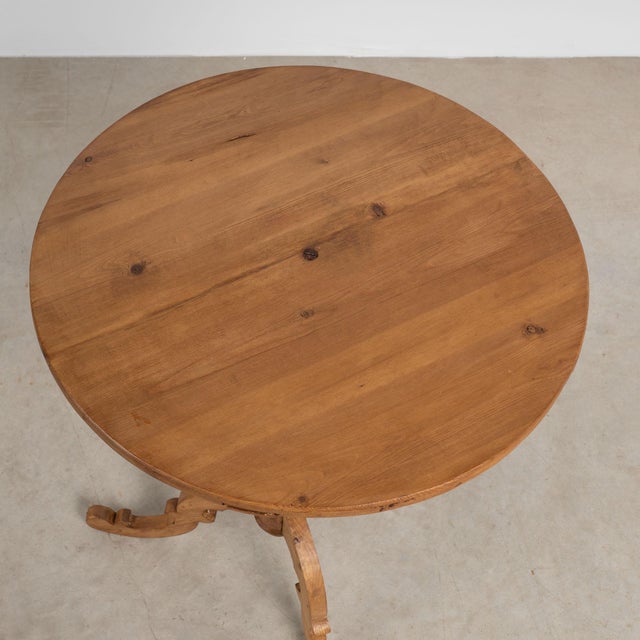 This antique round pine side table is charming with it's softly rounded edges, turned pedestal base and decoratively...