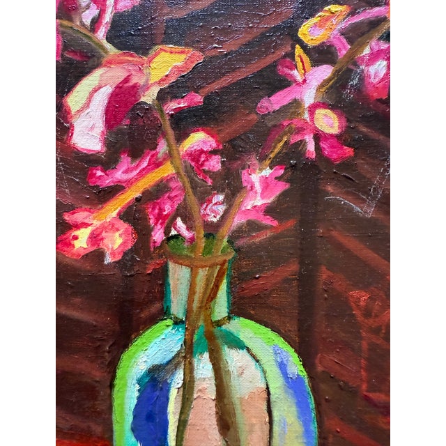 This intimate still life features a loose arrangement of pink orchids—in a faceted glass vase set against a wood paneled...