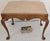 A refined antique upholstered stool in the Queen Anne tradition, featuring gracefully shaped cabriole legs terminating in...
