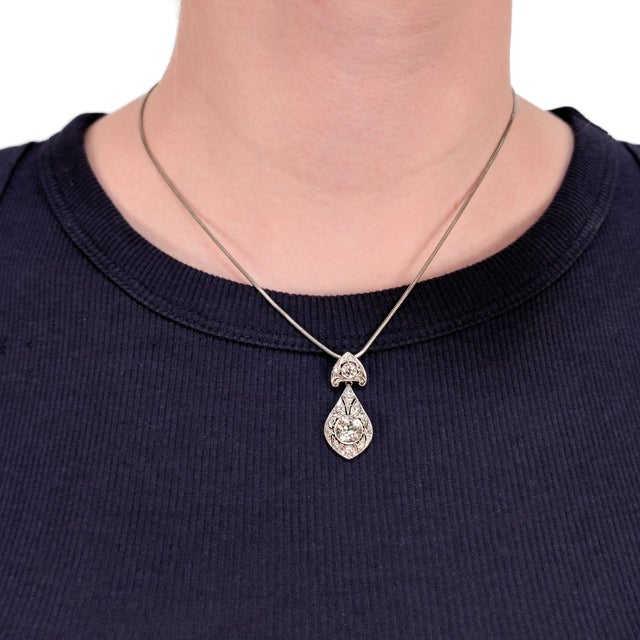 A fine antique platinum and diamond pendant. In platinum. With a central bezel-set Old European cut diamond (2.00± Ct)...