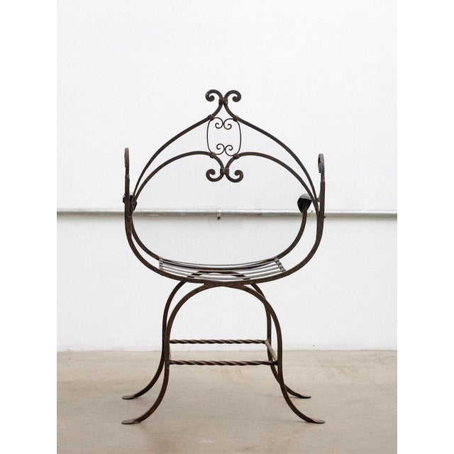 Artisan made mid century Spanish style iron savonarola chair. Throne like silhouette with whimsical details.