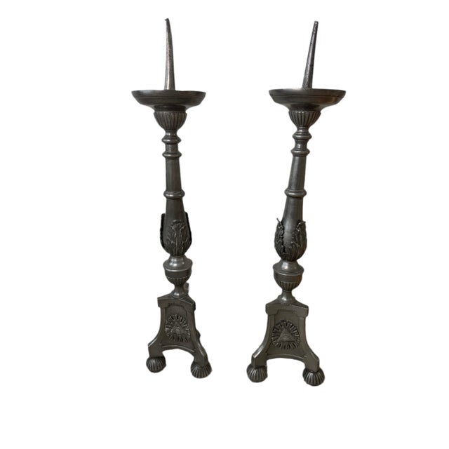 A dramatic and architecturally scaled pair of pewter-tone candlesticks featuring a striking Eye of Providence motif framed...
