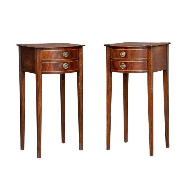 A very fine pair of French bowfront nightstands or bedside tables of patinated flame walnut. The tables feature a classic...