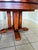 Dining table made of solid pine, decorated with ceramic accents and black leather strips on the legs. The table features a...