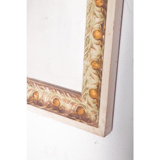 This elegant rectangular mirror features a finely crafted wooden frame, painted in a soft light green with delicate gilt...