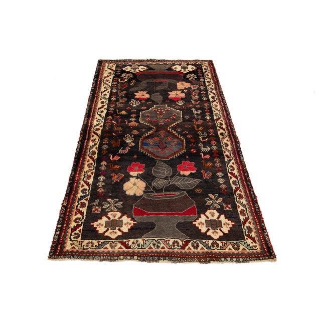 Vintage Persian Handmade wool rug with a dark brown field and multicolored accents all over the design. This rug measures...