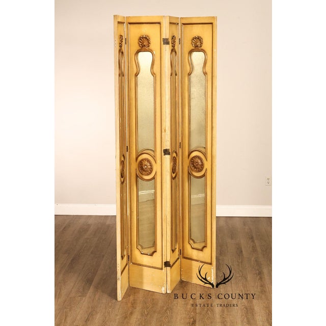 Decorative four-panel folding screen featuring a painted faux-gilt finish, antiqued mirror inserts, and carved Rococo-...