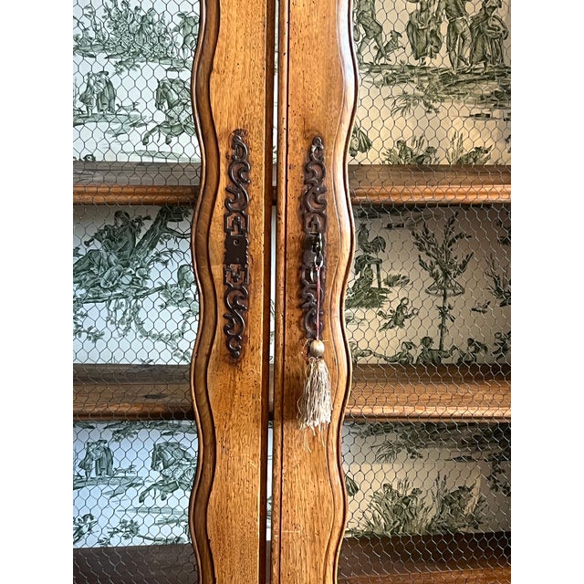 Antique 19th-century French cherrywood bookcase, with carved details, and two wire mesh paneled doors backed with padded...