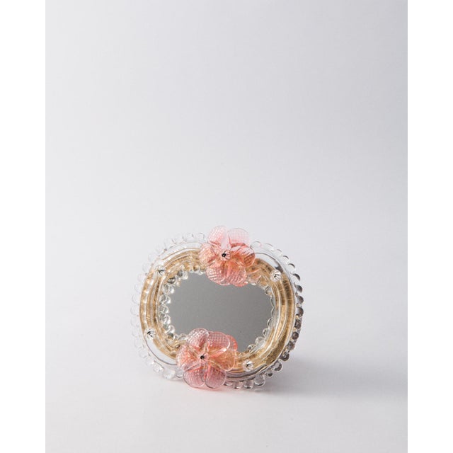 This Murano glass mirror is handcrafted in Venice by a centuries-old atelier known for its masterful ornamentation. A...