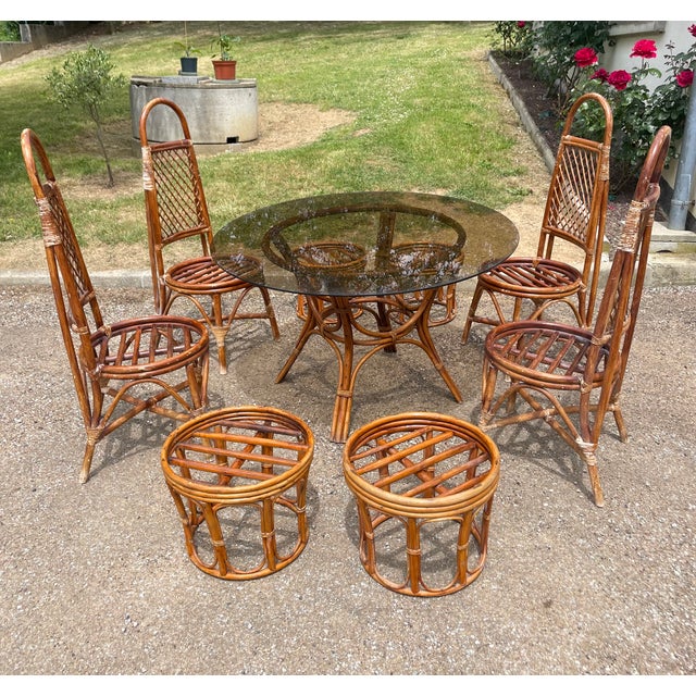 Beautiful vintage rattan set of four chairs, a table with a glass top, and four ottoman stools. excellent condition....