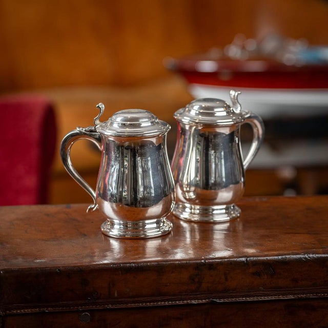 Antique 20th Century pair of Italian solid silver lidded tankards, the domed lid is applied with a cast thumb-piece, the...