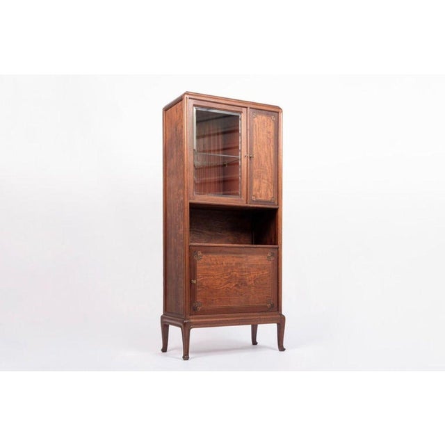 This exquisite antique French Art Nouveau inlaid wood and glass cabinet was designed by Louis Majorelle and made in Nancy,...