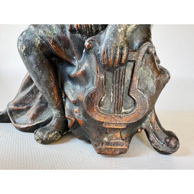 Original antique figural crest removed from an Ansonia mantel clock, depicting a seated classical woman resting beside a...