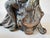 Original antique figural crest removed from an Ansonia mantel clock, depicting a seated classical woman resting beside a...