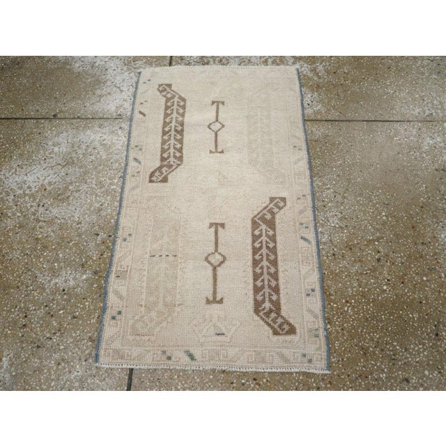 This mid-20th-century Turkish Anatolian rug, measuring 1' 8" × 2' 11", showcases the minimalist beauty and symbolic...