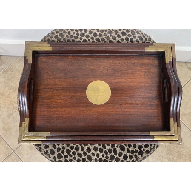 Elegant vintage set of three mahogany nesting trays with classic brass corner accents and round brass medallion inlays....
