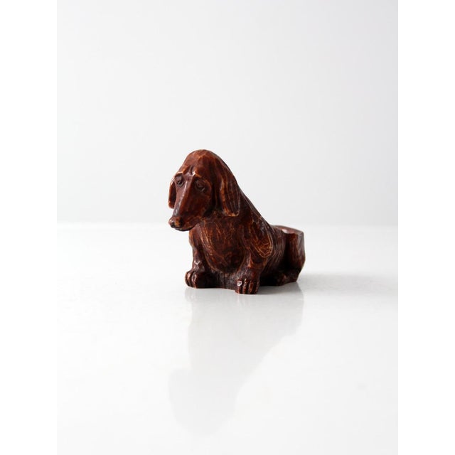 This 1950s Comoy’s pipe rest is crafted in the shape of a hound dog, made from cast composite wood in the Syroco style....